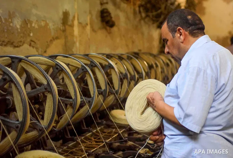 A worker prepares wool for production in a factory in Beheira Governorate, Egypt on September 3, 2016. Photo by Amr Sayed