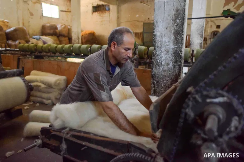 A worker prepares wool for production in a factory in Beheira Governorate, Egypt on September 3, 2016. Photo by Amr Sayed