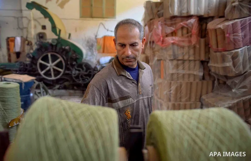 A worker prepares wool for production in a factory in Beheira Governorate, Egypt on September 3, 2016. Photo by Amr Sayed