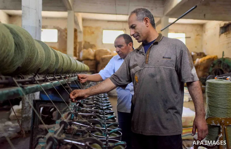A worker prepares wool for production in a factory in Beheira Governorate, Egypt on September 3, 2016. Photo by Amr Sayed