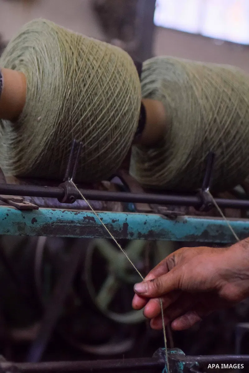 A worker prepares wool for production in a factory in Beheira Governorate, Egypt on September 3, 2016. Photo by Amr Sayed