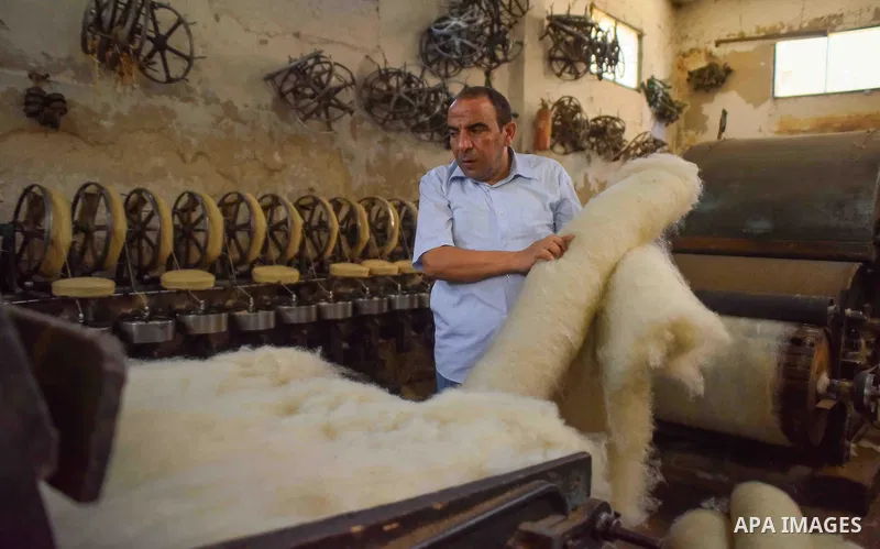 A worker prepares wool for production in a factory in Beheira Governorate, Egypt on September 3, 2016. Photo by Amr Sayed