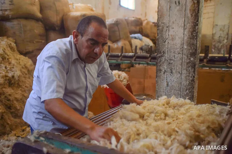 A worker prepares wool for production in a factory in Beheira Governorate, Egypt on September 3, 2016. Photo by Amr Sayed