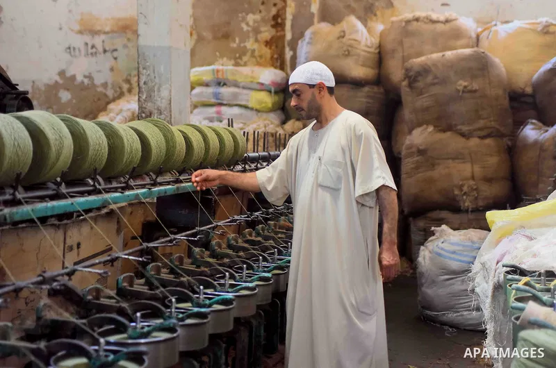 A worker prepares wool for production in a factory in Beheira Governorate, Egypt on September 3, 2016. Photo by Amr Sayed