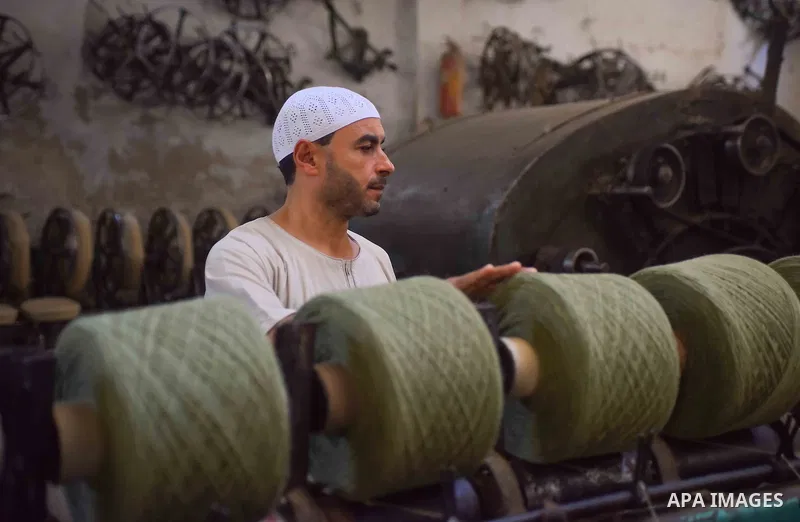 A worker prepares wool for production in a factory in Beheira Governorate, Egypt on September 3, 2016. Photo by Amr Sayed