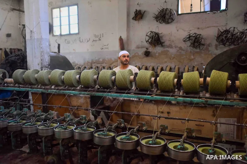 A worker prepares wool for production in a factory in Beheira Governorate, Egypt on September 3, 2016. Photo by Amr Sayed
