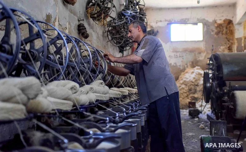 A worker prepares wool for production in a factory in Beheira Governorate, Egypt on September 3, 2016. Photo by Amr Sayed
