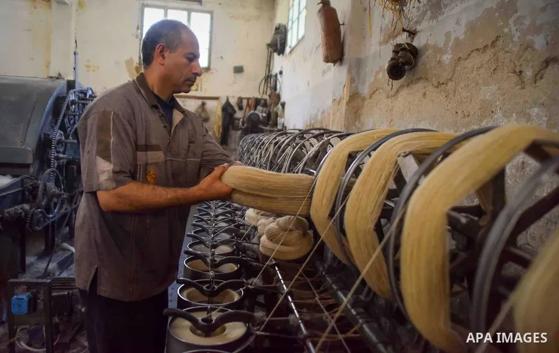 A worker prepares wool for production in a factory in Beheira Governorate, Egypt on September 3, 2016. Photo by Amr Sayed