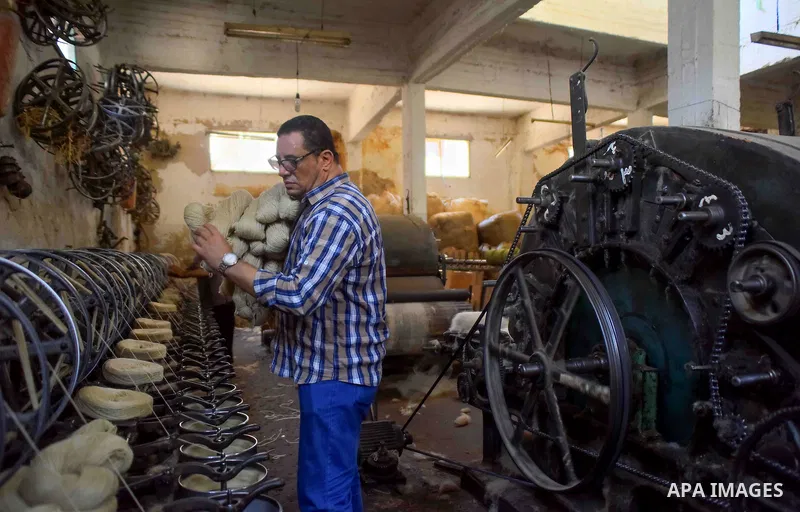 A worker prepares wool for production in a factory in Beheira Governorate, Egypt on September 3, 2016. Photo by Amr Sayed