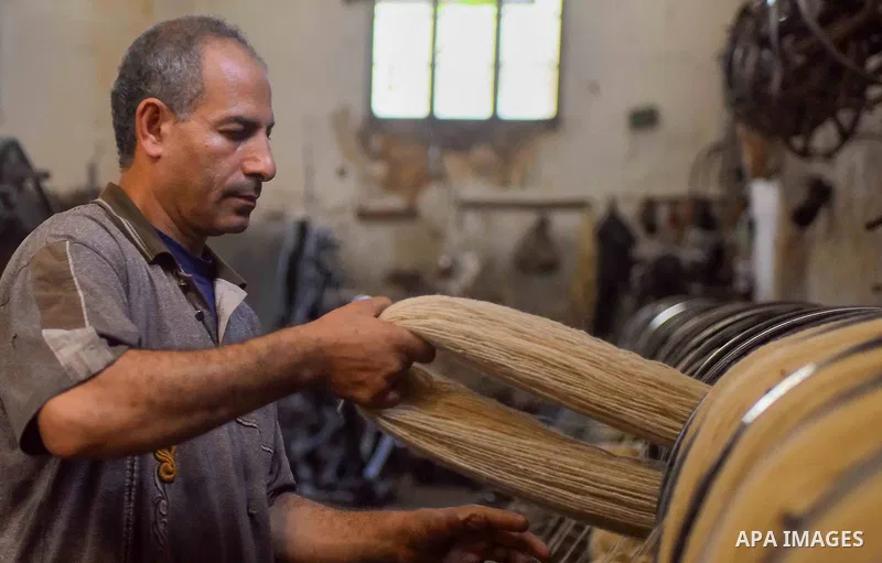 A worker prepares wool for production in a factory in Beheira Governorate, Egypt on September 3, 2016. Photo by Amr Sayed