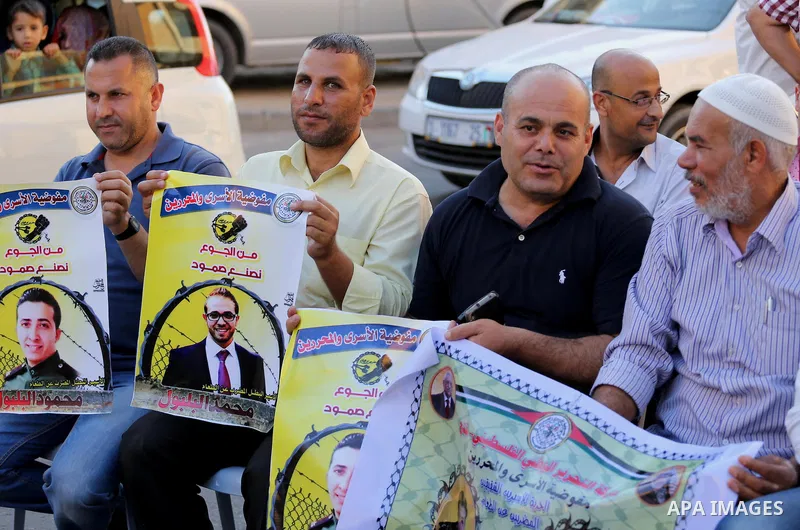 Palestinian supporters of Fatah movement take part during a protest to show solidarity with Palestinian prisoners on hunger strike in Israeli Jails, in front of Red cross office in Gaza city, on Sept. 18, 2016. Photo by...