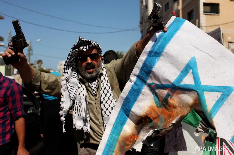 Palestinians burn posters bearing Israeli flag during a protest demanding release the prisoners in Israeli jails, in front of Red cross office in Gaza city, on Sept. 19, 2016. Photo by Ashraf Amra