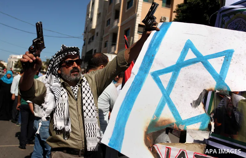 Palestinians burn posters bearing Israeli flag during a protest demanding release the prisoners in Israeli jails, in front of Red cross office in Gaza city, on Sept. 19, 2016. Photo by Ashraf Amra