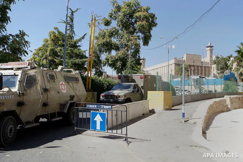 Israeli security forces cordon off the area around the body of a Palestinian, who was shot during a reported stabbing attack against Israeli officers, near the Ibrahimi mosque, or the Tomb of the Patriarch, a religious s...