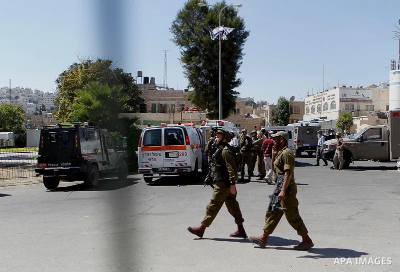 Israeli security forces cordon off the area around the body of a Palestinian, who was shot during a reported stabbing attack against Israeli officers, near the Ibrahimi mosque, or the Tomb of the Patriarch, a religious s...