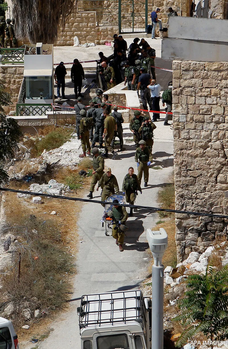 Israeli security forces carry the body of a Palestinian, who was shot during a reported stabbing attack against Israeli officers, near the Ibrahimi mosque, or the Tomb of the Patriarch, a religious site to both Muslims a...