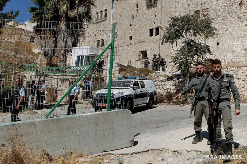 Israeli security forces cordon off the area around the body of a Palestinian, who was shot during a reported stabbing attack against Israeli officers, near the Ibrahimi mosque, or the Tomb of the Patriarch, a religious s...
