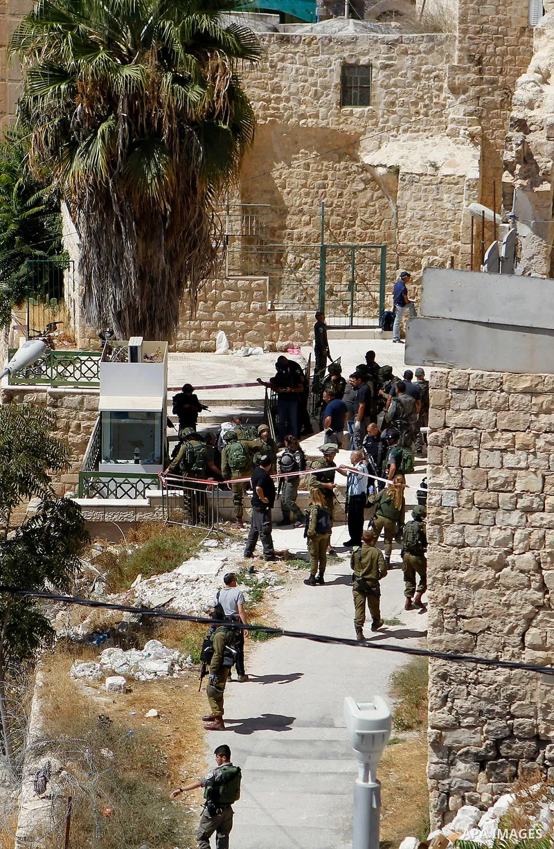 Israeli security forces cordon off the area around the body of a Palestinian, who was shot during a reported stabbing attack against Israeli officers, near the Ibrahimi mosque, or the Tomb of the Patriarch, a religious s...