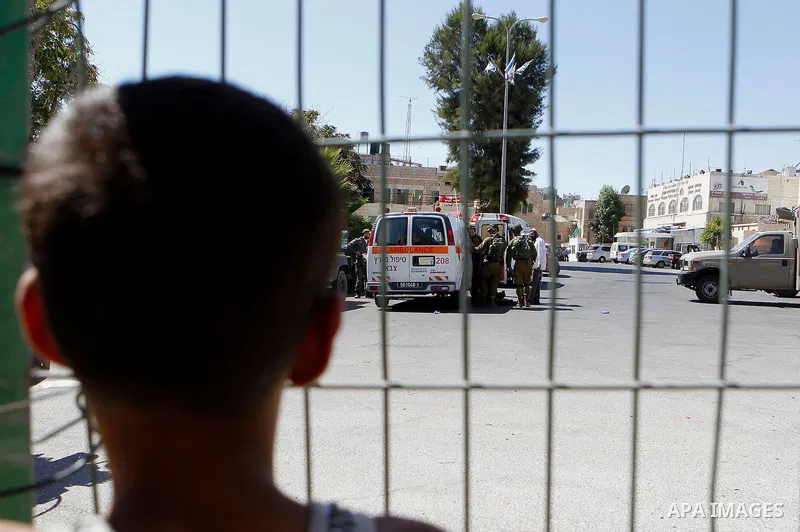 Israeli security forces carry the body of a Palestinian, who was shot during a reported stabbing attack against Israeli officers, near the Ibrahimi mosque, or the Tomb of the Patriarch, a religious site to both Muslims a...