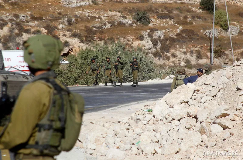 Israeli security forces stand at the scene where a Palestinian attempted to stab an Israeli soldier at the entrance to the West Bank village of Bani Na'im, near Hebron September 20, 2016. Photo by Wisam Hashlamoun