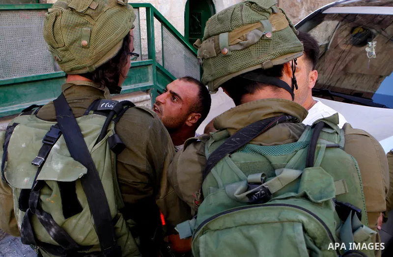 Israeli soldiers detain a Palestinian during a searching raid by Israeli troops, in the West Bank city of Hebron September 20, 2016. Photo by Wisam Hashlamoun