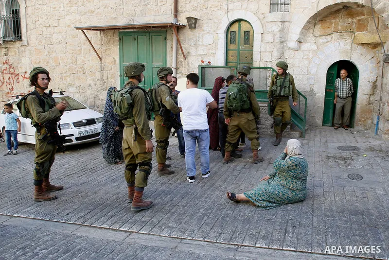 Israeli soldiers detain a Palestinian during a searching raid by Israeli troops, in the West Bank city of Hebron September 20, 2016. Photo by Wisam Hashlamoun
