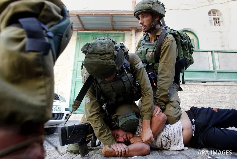 Israeli soldiers detain a Palestinian during a searching raid by Israeli troops, in the West Bank city of Hebron September 20, 2016. Photo by Wisam Hashlamoun