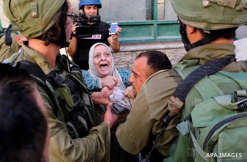 Israeli soldiers detain a Palestinian during a searching raid by Israeli troops, in the West Bank city of Hebron September 20, 2016. Photo by Wisam Hashlamoun