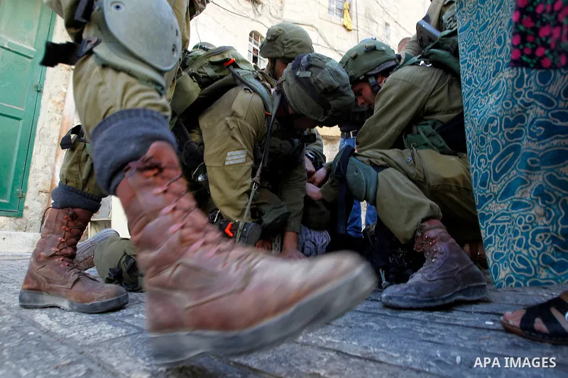 Israeli soldiers detain a Palestinian during a searching raid by Israeli troops, in the West Bank city of Hebron September 20, 2016. Photo by Wisam Hashlamoun