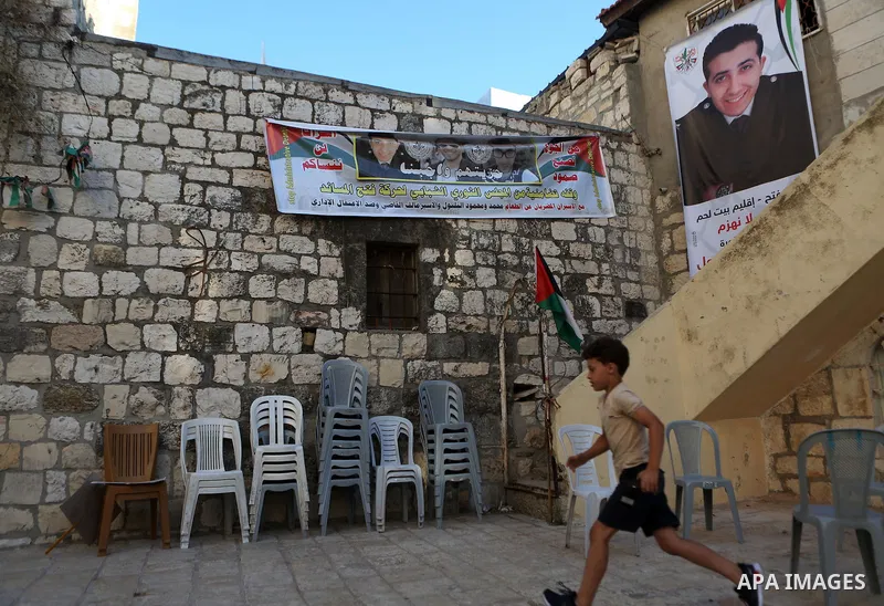 A Palestinian boy runs in front of posters bearing pictures of Palestinian prisoners Mohammed and Mahmoud Balboul who are on hunger strike, in their house, in the West Bank city of Bethlehem on Sep. 20, 2016. Mohammed Ba...