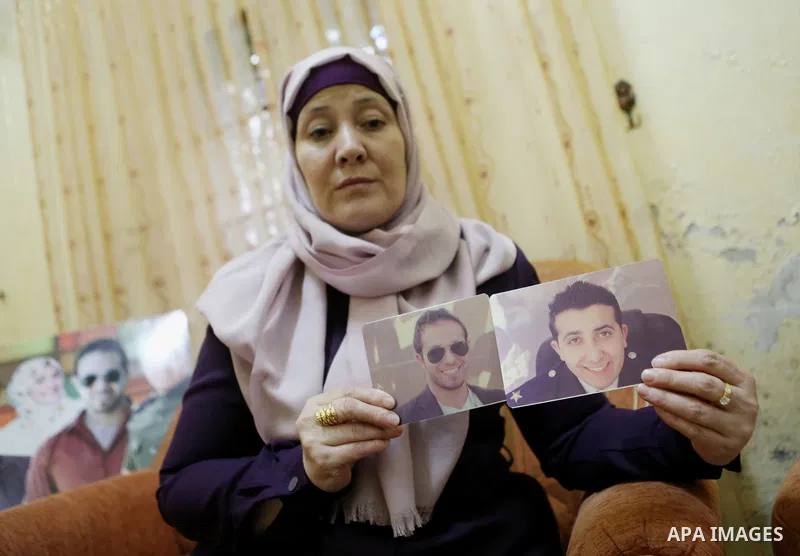 Sana Balboul, the mother of Hunger-striking Palestinian prisoners Mohammed and Mahmoud Balboul holds pictures for them at her house in the West Bank city of Bethlehem on Sep. 20, 2016. Mohammed Balboul began his own hung...