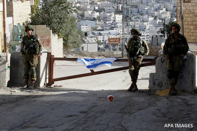 Israeli army soldiers stand guard at a checkpoint in Tal Rumaida in the West Bank city of Hebron, September 21 2016 . the Israeli army applied a closure on areas where the army says Palestinian assailants attacked Israel...
