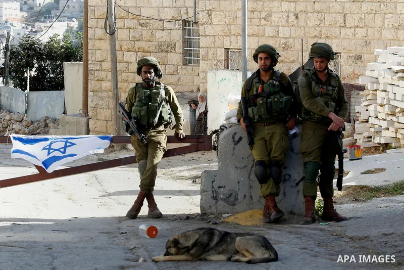 Israeli army soldiers stand guard at a checkpoint in Tal Rumaida in the West Bank city of Hebron, September 21 2016 . the Israeli army applied a closure on areas where the army says Palestinian assailants attacked Israel...