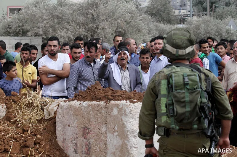 Palestinian protesters take part during a protest in front of Israeli soldiers against the closure of the entrance of the Beta village by the Israeli army following Friday prayers, next to the Beta Junction east West Ban...
