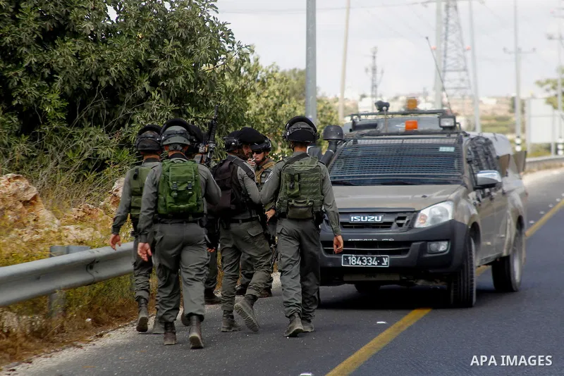 Israeli security forces gather at the area next to a road in the occupied southern West Bank at the entrance of the Israeli settlement of Kiryat Arba, on September 23, 2016, after a Palestinian was shot and wounded as he...