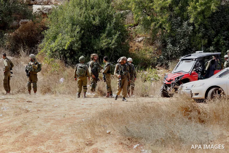 Israeli security forces gather at the area next to a road in the occupied southern West Bank at the entrance of the Israeli settlement of Kiryat Arba, on September 23, 2016, after a Palestinian was shot and wounded as he...