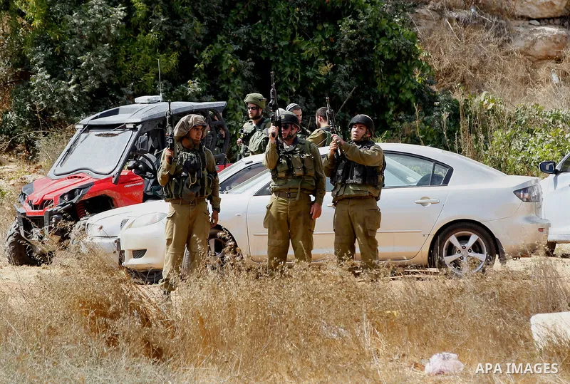 Israeli security forces gather at the area next to a road in the occupied southern West Bank at the entrance of the Israeli settlement of Kiryat Arba, on September 23, 2016, after a Palestinian was shot and wounded as he...