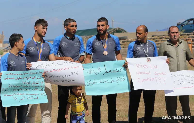 Palestinian sportsmen hold banners during a protest against the Israeli authorities to prevent their travel to Vietnam through the Erez crossing, in Gaza city, on Sept. 24, 2016. Photo by Mohammed Asad