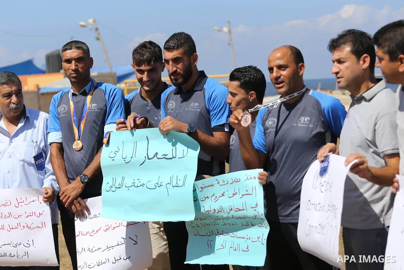Palestinian sportsmen hold banners during a protest against the Israeli authorities to prevent their travel to Vietnam through the Erez crossing, in Gaza city, on Sept. 24, 2016. Photo by Mohammed Asad