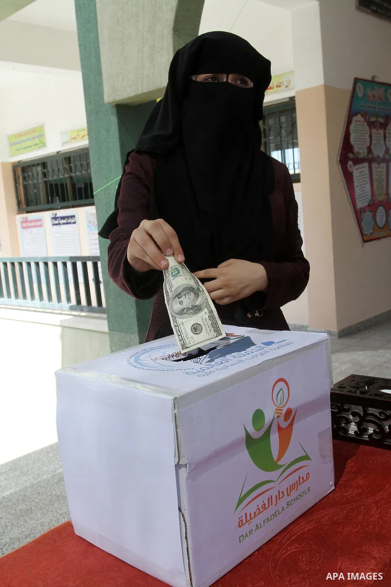 Palestinian teachers from al-Fadela school donates money during a rally supporting of a Gaza-bound flotilla of international activists attempting to break the Gaza blockade, in Rafah in the southern Gaza strip on Septemb...