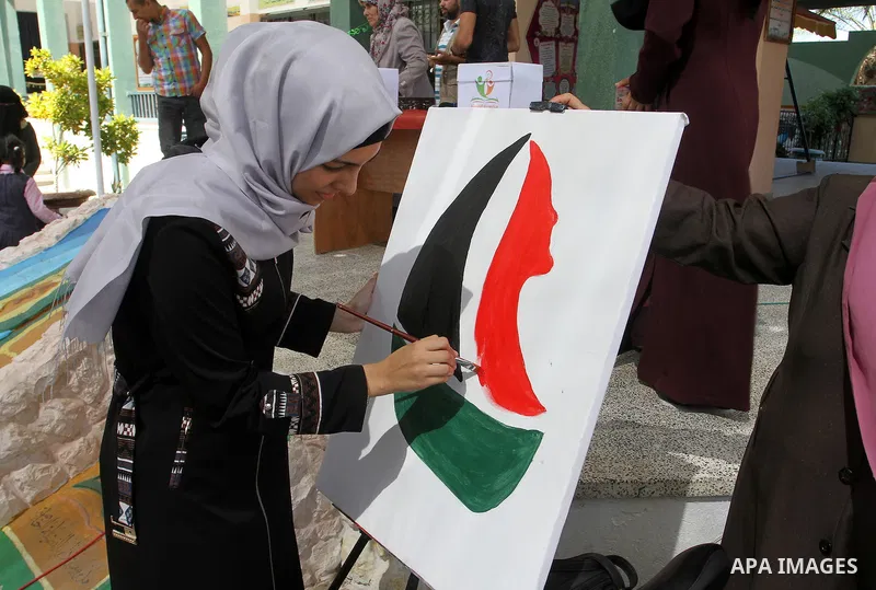 A Palestinian artist paints artwork in a rally supporting of a Gaza-bound flotilla of international activists attempting to break the Gaza blockade, in Rafah in the southern Gaza strip on September 25, 2016. Photo by Abe...