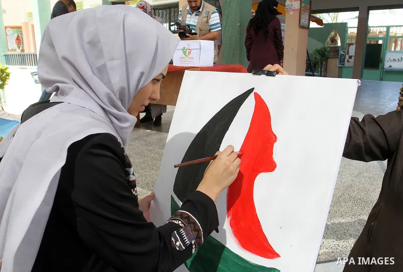 A Palestinian artist paints artwork in a rally supporting of a Gaza-bound flotilla of international activists attempting to break the Gaza blockade, in Rafah in the southern Gaza strip on September 25, 2016. Photo by Abe...
