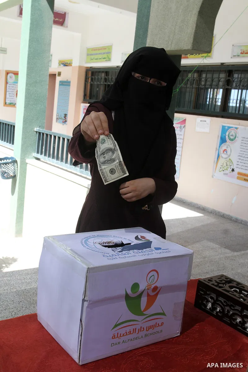 Palestinian teachers from al-Fadela school donates money during a rally supporting of a Gaza-bound flotilla of international activists attempting to break the Gaza blockade, in Rafah in the southern Gaza strip on Septemb...