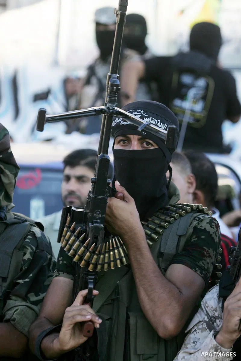 Palestinian militants from the Al-Nasser Brigades, an armed wing of the Popular Resistance Committees (PRC), hold their weapons during a rally in Rafah in the southern Gaza Strip on September 26, 2016, to mark the 17th a...