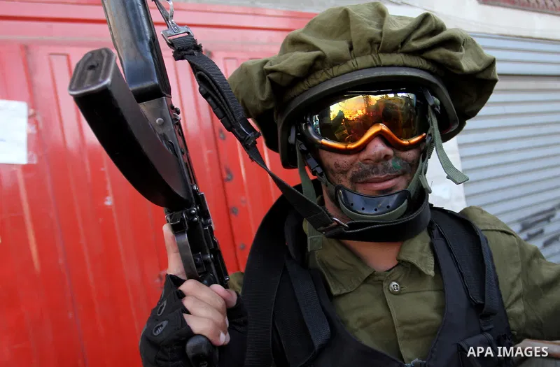 Palestinian militants from the Al-Nasser Brigades, an armed wing of the Popular Resistance Committees (PRC), hold their weapons during a rally in Rafah in the southern Gaza Strip on September 26, 2016, to mark the 17th a...