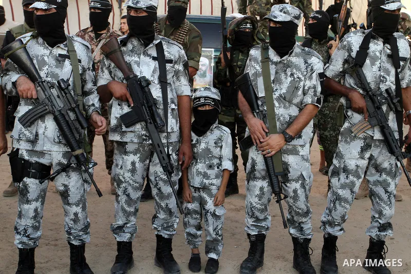 Palestinian militants from the Al-Nasser Brigades, an armed wing of the Popular Resistance Committees (PRC), hold their weapons during a rally in Rafah in the southern Gaza Strip on September 26, 2016, to mark the 17th a...