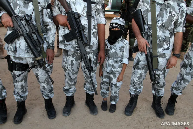 Palestinian militants from the Al-Nasser Brigades, an armed wing of the Popular Resistance Committees (PRC), hold their weapons during a rally in Rafah in the southern Gaza Strip on September 26, 2016, to mark the 17th a...