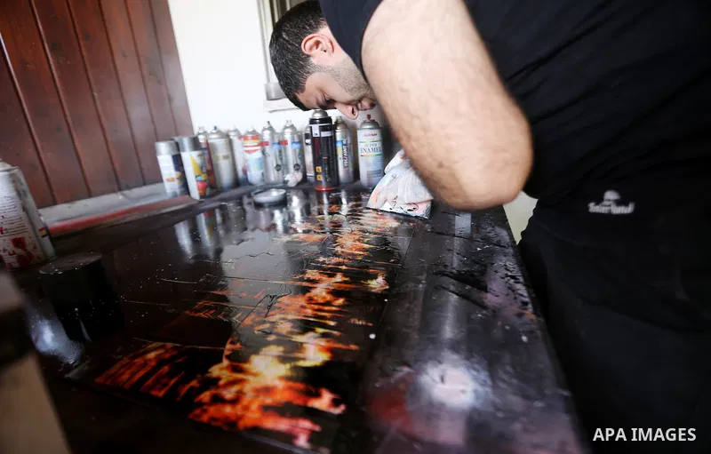 A Palestinian artist Khaled Salama, 27, works on the final touches of his sand painting, at his work shop in the West Bank city of Salfit, on Sep. 27, 2016. Photo by Shadi Hatem
