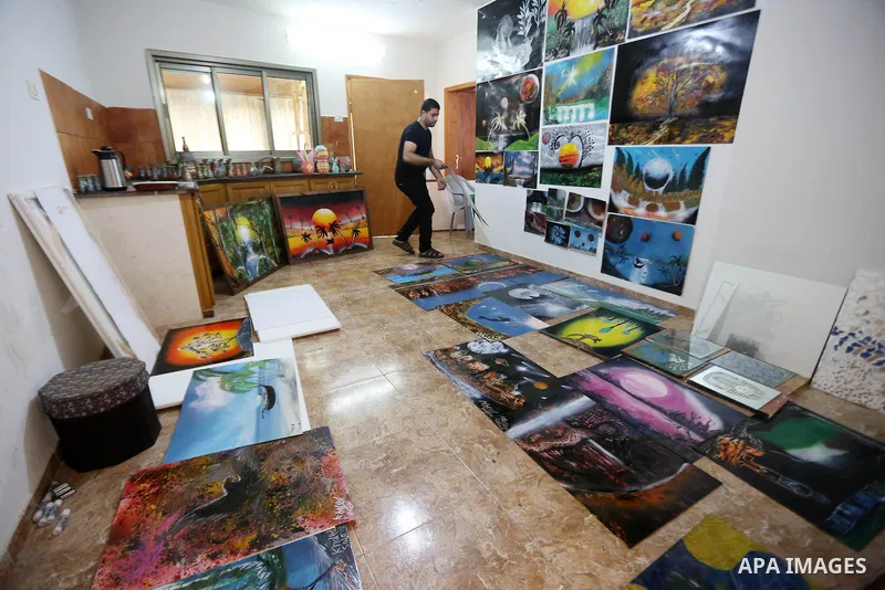 A Palestinian artist Khaled Salama, 27, displays his sand painting, at his work shop in the West Bank city of Salfit, on Sep. 27, 2016. Photo by Shadi Hatem