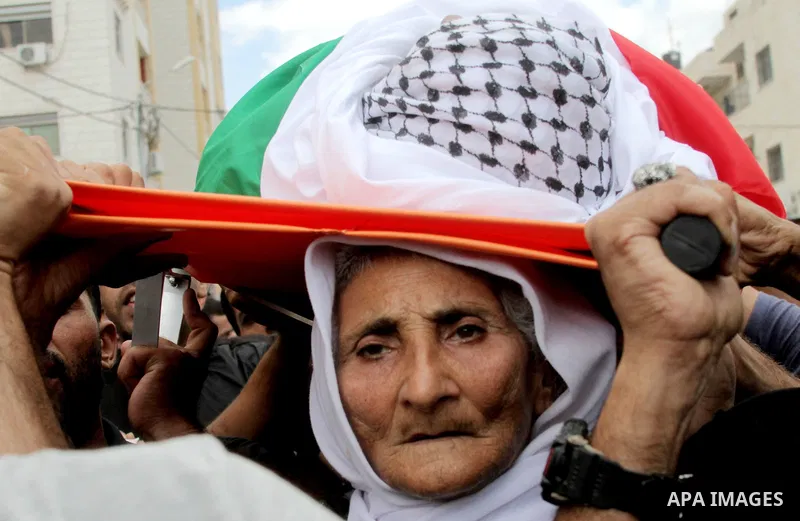 The mother of Palestinian Yassir Hamduni carries his body during the funeral in the west bank village of Yabad, near Jenin City, on September 27, 2016. Hamduni died of a heart condition in Israeli prison on Sunday after...